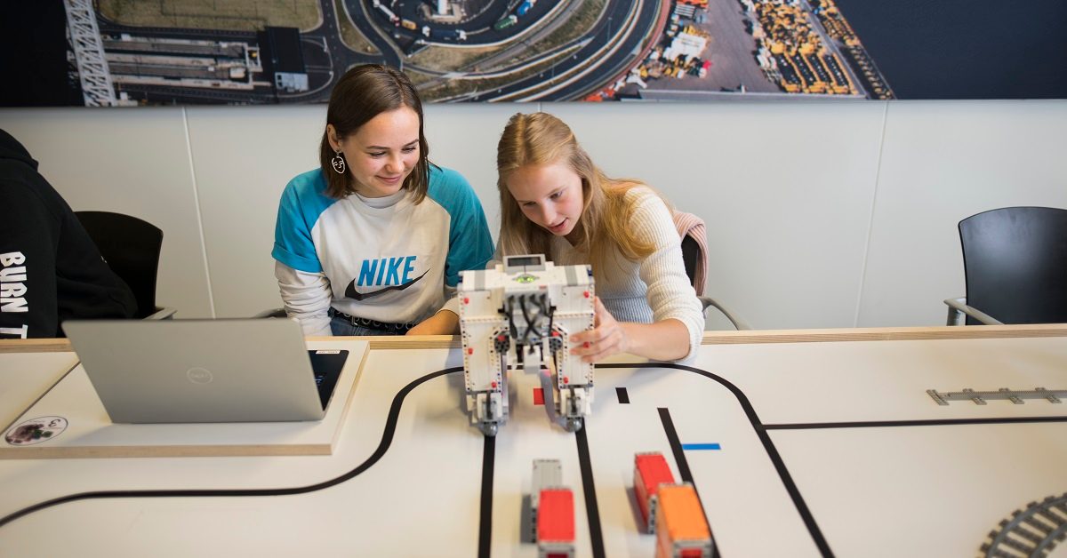 2 jongeren programmeren de straddle carrier uit LEGO